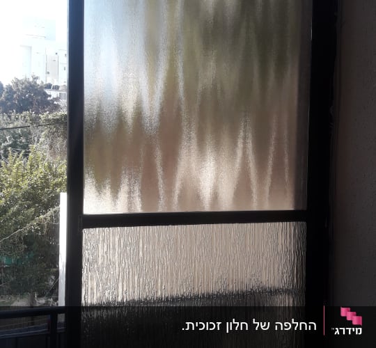 זכוכית מחוספסת בחלון עם מסגרת כהה